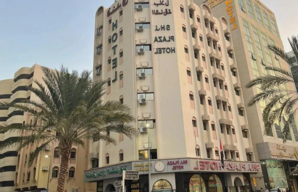 Sharjah Plaza Hotel building and palm trees